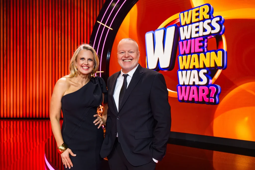Moderationspaar vor dem Logo von „Wer weiß wie wann was war?“