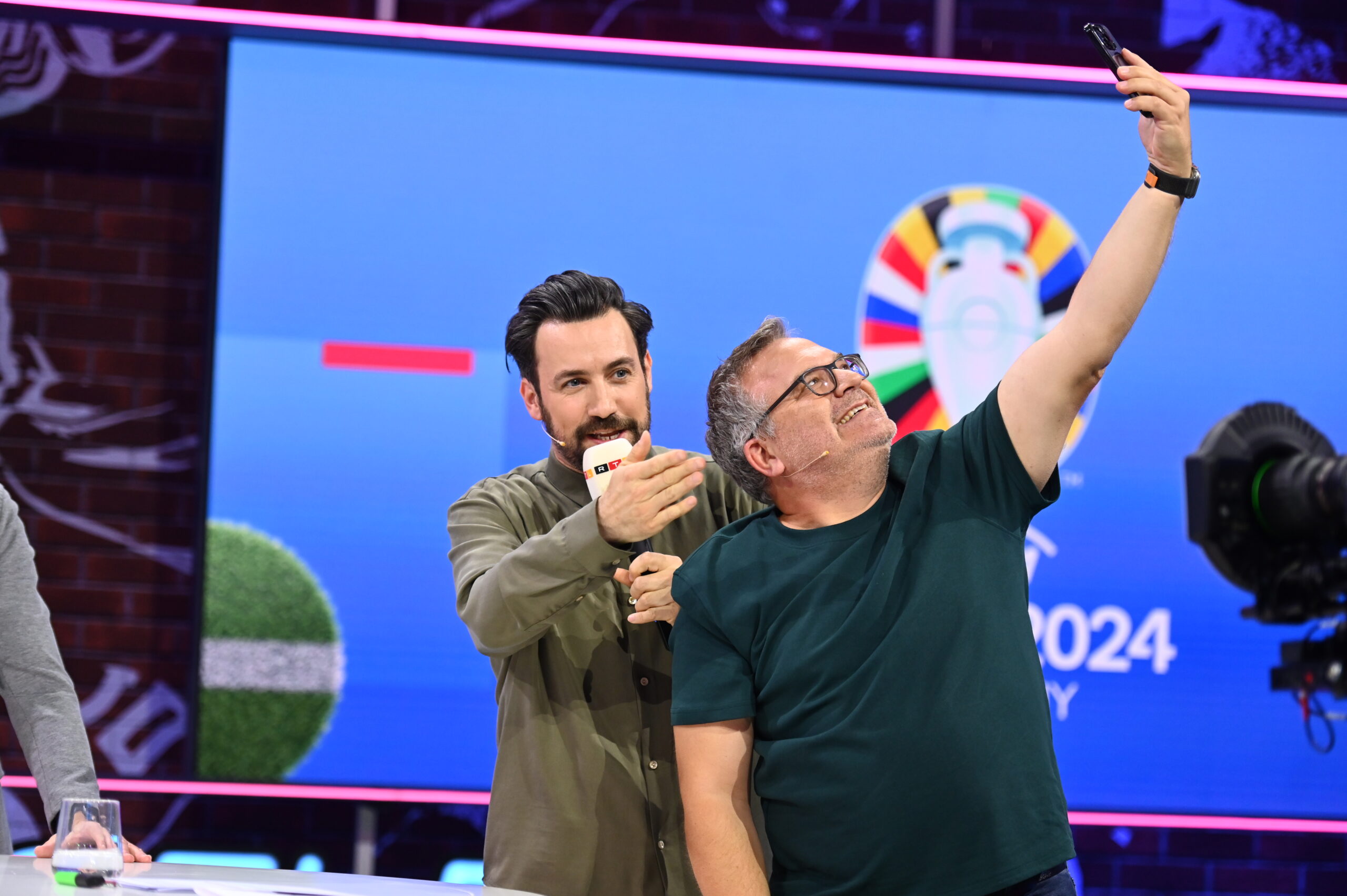 Zwei Männer machen ein Selfie im TV-Studio zur Fußball-EM 2024
